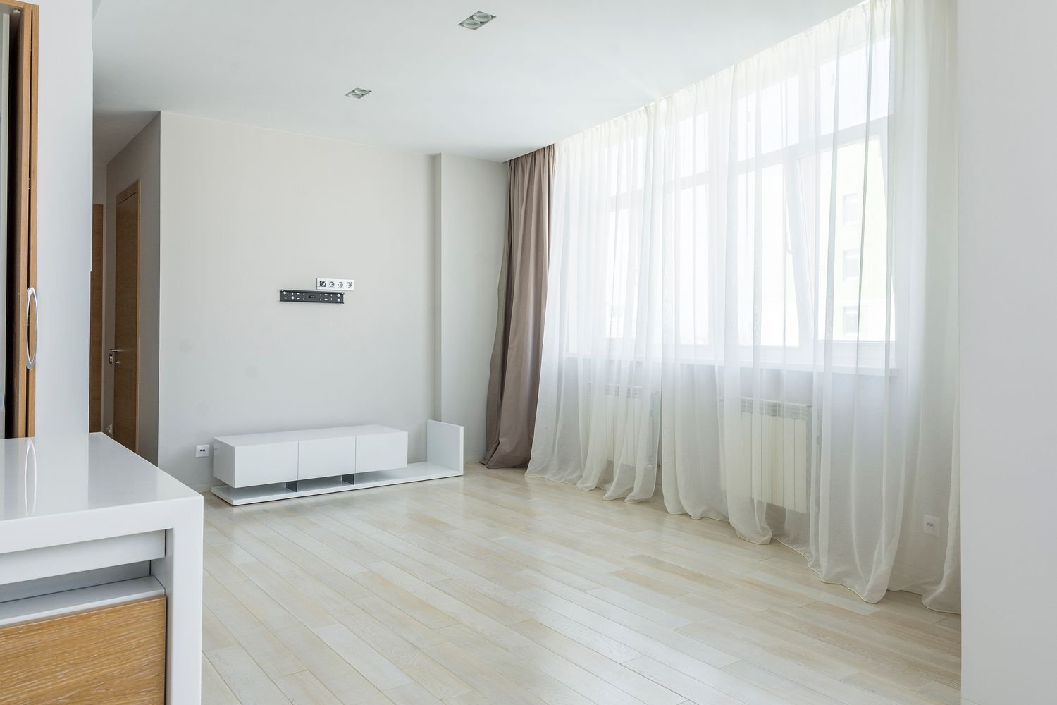 Modern minimalist Dubai apartment living room with sheer and blackout curtain combination on floor-to-ceiling windows