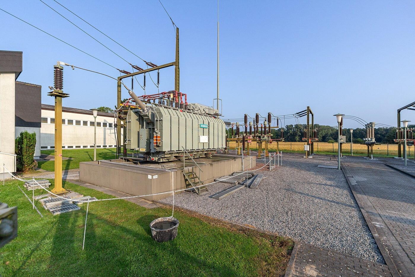Compact packaged distribution substation building at street level with ventilation louvres and direct road access, illustrating the space, access and clearance requirements DEWA imposes when connected load exceeds 400 kW