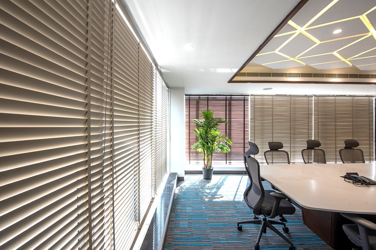 Boardroom fit-out with a coffered gypsum ceiling, recessed cove LED strip, linear HVAC grille, carpet tiles and timber-veneer joinery table - the ceiling, MEP and joinery lines that most often differ between two Dubai fit-out quotations