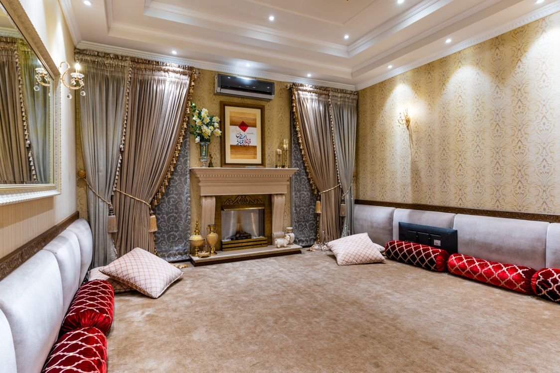 Luxurious traditional Arabic sitting room with plush cushions and warm gold lighting — UAE majlis interior design 2026