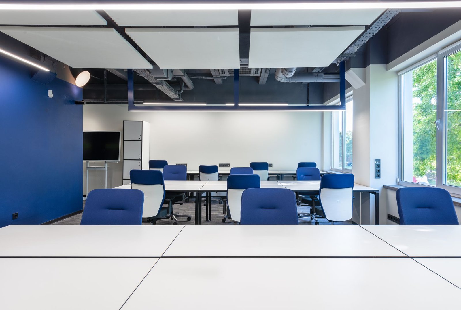 Modern Dubai office interior design showing workstations, feature wall and executive meeting room