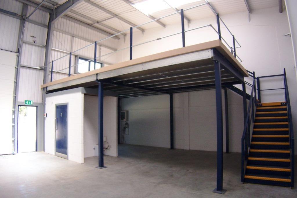Warehouse mezzanine floor Dubai - steel mezzanine structure with beams, columns, chipboard deck and a twin flight staircase inside an industrial unit